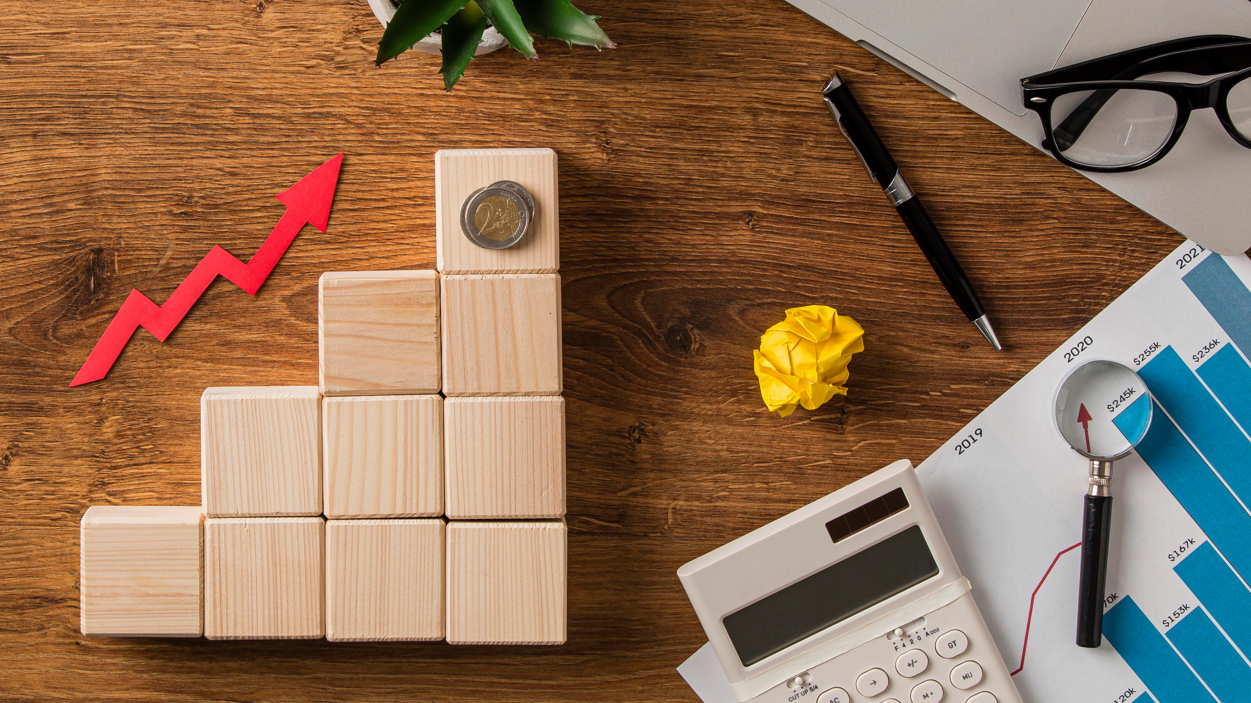 top-view-business-items-growth-arrow-with-wooden-blocks